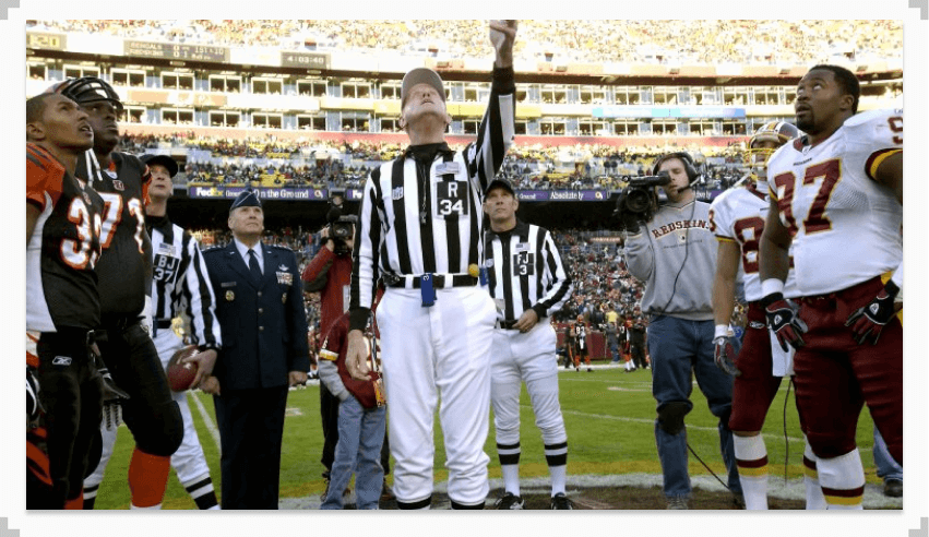 photo of a referee tossing a coin at a football game featuring cleveland and washington