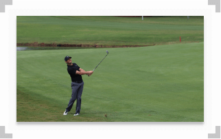 Rory McIlroy on golf course watching golf ball after swing