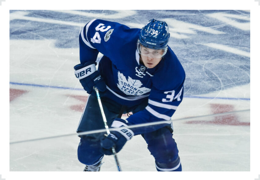 Auston Matthews skating two hand on stick Leafs jersey