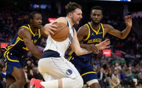 Dallas Mavericks forward Luka Doncic tries to dribble past Golden State Warriors forwards Jonathan Kuminga and Andrew Wiggins