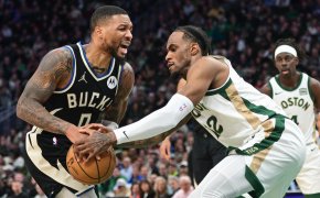 Milwaukee Bucks guard Damian Lillard and Boston Celtics forward Oshae Brissett battle for the ball