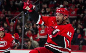 Carolina Hurricanes player Jordan Martinook celebrating goal arms raised red jersey
