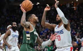 Milwaukee Bucks guard Damian Lillard drives against LA Clippers forward Paul George