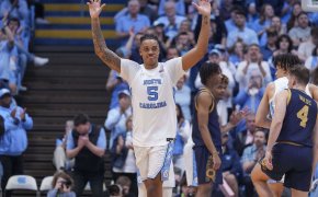 UNC Tar Heels college basketball player raising hands white jersey
