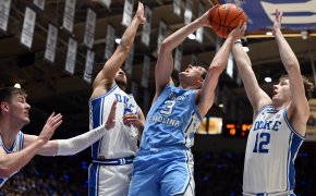 North Carolina player shooting over Duke defenders